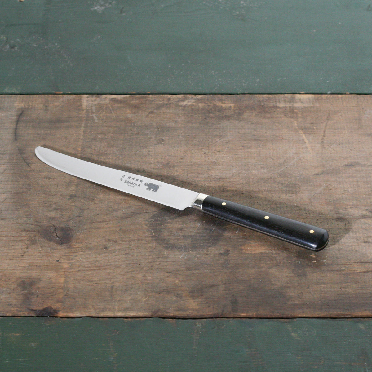 Vintage French Steak Knife with ebony handle on a wooden table