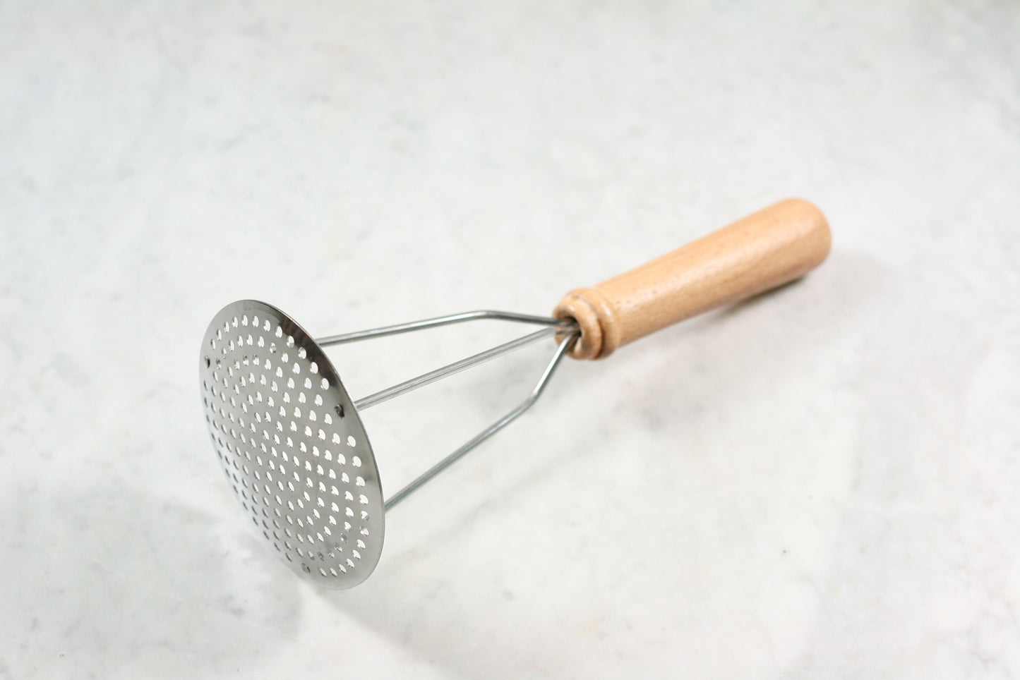 Stainless steel potato masher with wooden handle, made in France.