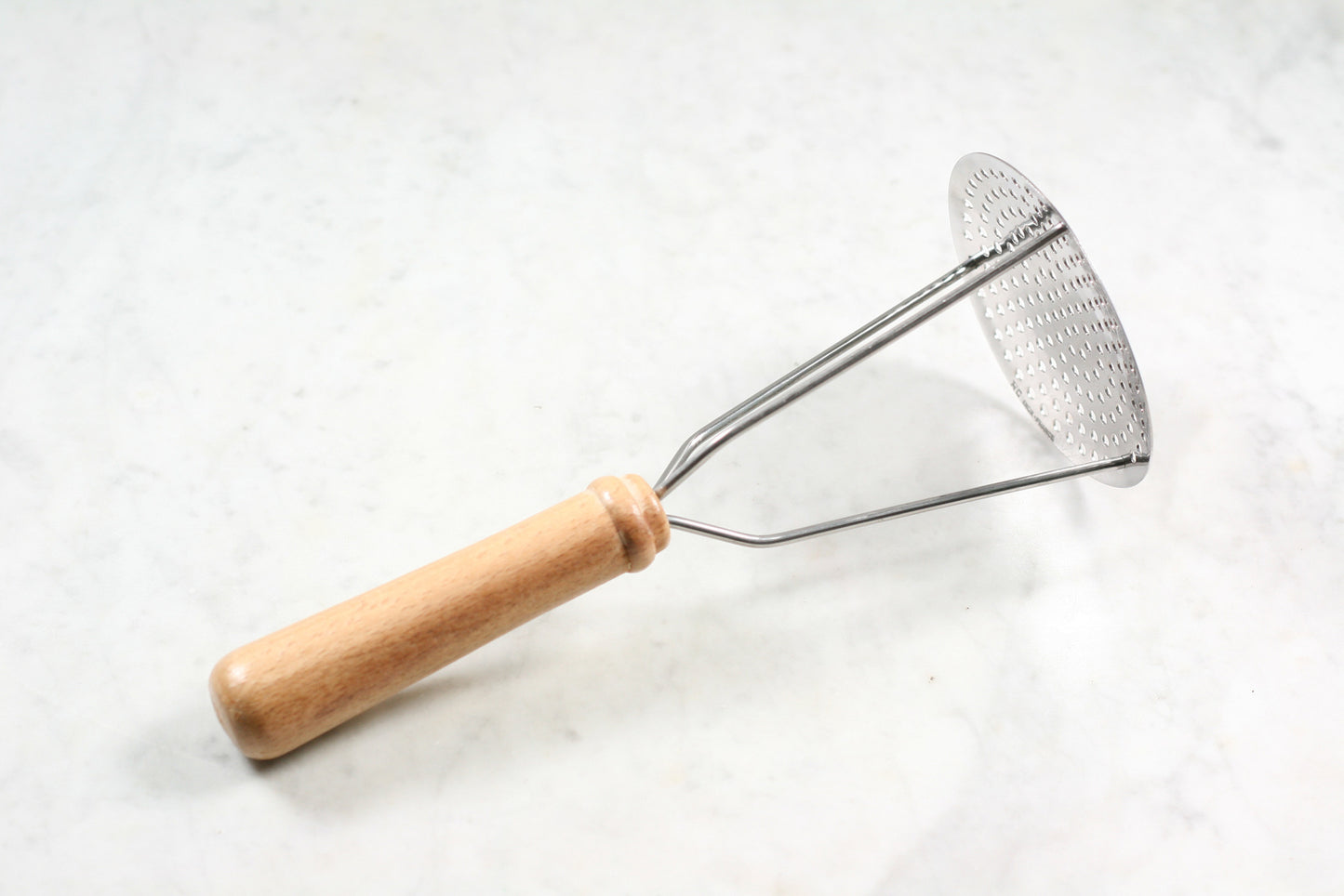 Stainless steel potato masher with wooden handle, made in France.