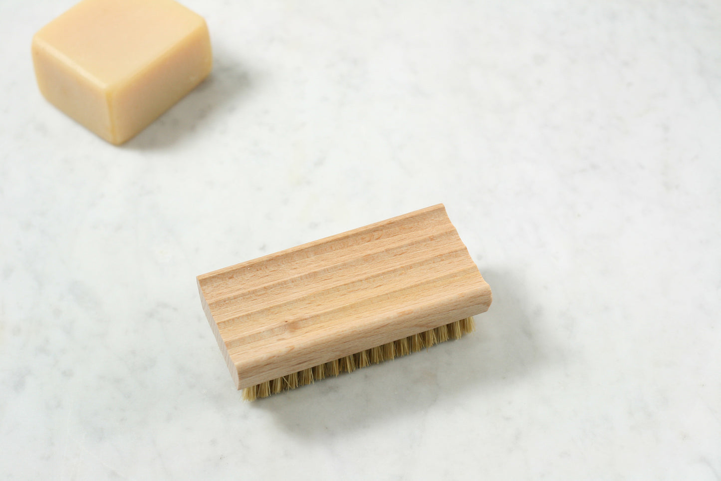 An oiled beechwood soap dish, with ridged surface, that does double duty as a nail brush. From Burstenhaus Redecker.